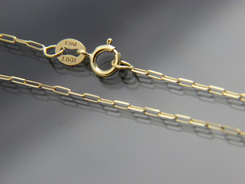 May include: A gold chain necklace with a lobster clasp and a tag that reads "ITAL 10KT".