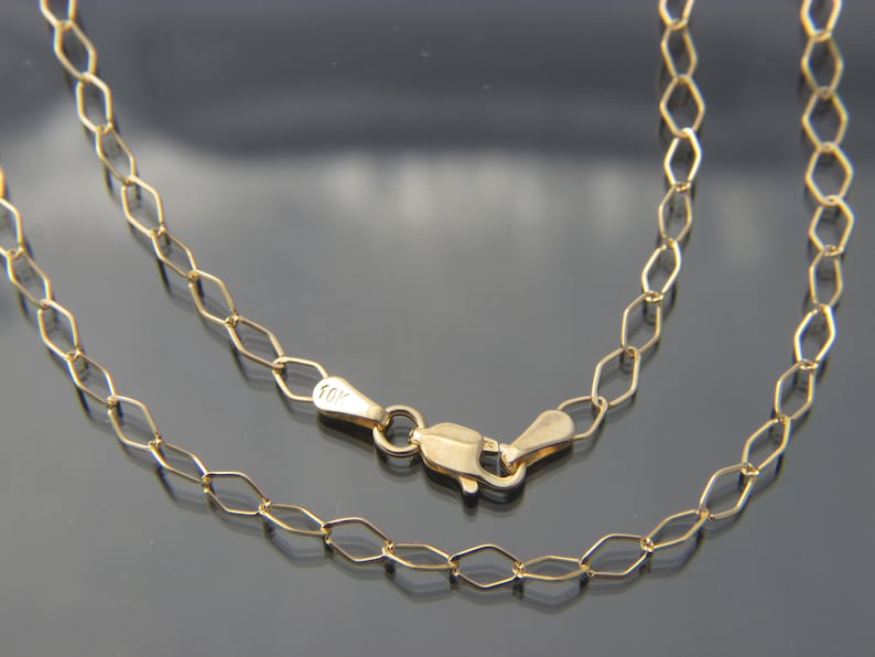 Puede incluir: Un collar de cadena de oro con cierre de mosquet&oacute;n. La cadena est&aacute; hecha de oro de 10 quilates y tiene un delicado patr&oacute;n de eslabones ovalados.