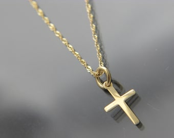 May include: A gold chain necklace with a small gold cross pendant.