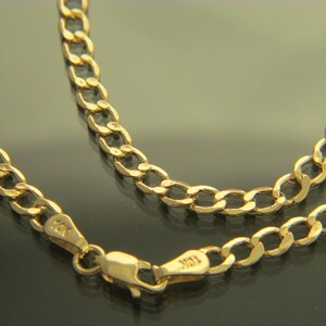 K&ouml;nnte beinhalten: Eine goldene Halskette mit einem Curb-Kettenglied-Design. Die Kette ist aus 10 Karat Gold gefertigt und hat einen Karabinerverschluss.