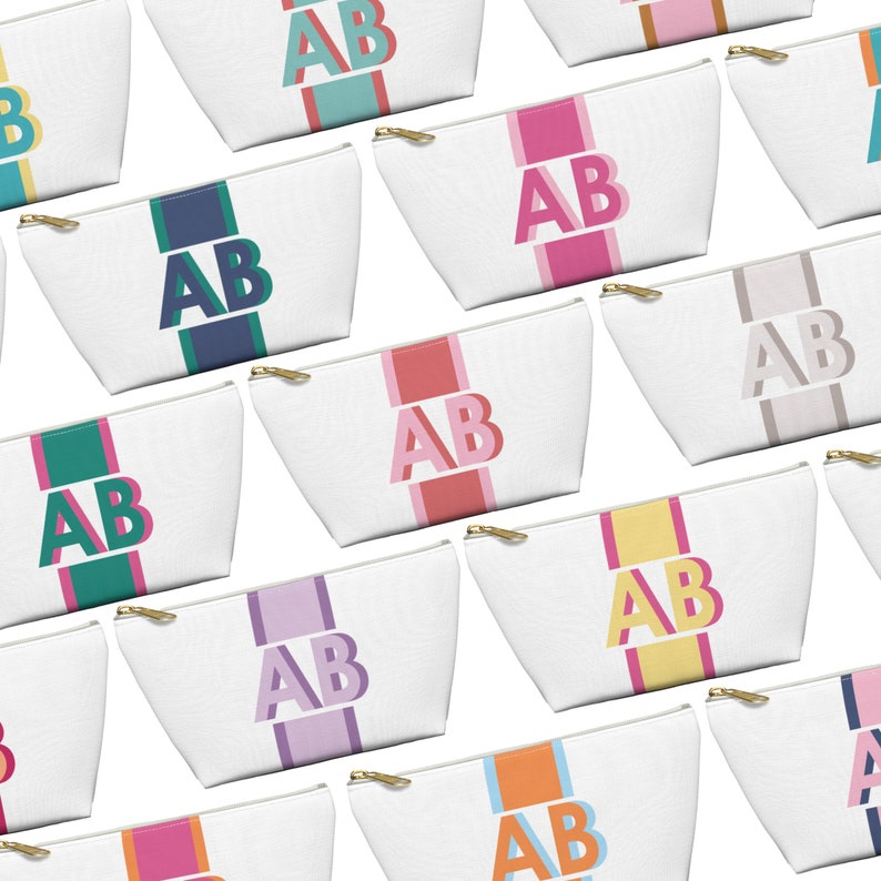 Op de afbeelding: Een verzameling witte ritszakjes met kleurrijke strepen en de letters "AB" in een vetgedrukt lettertype. De zakjes zijn gerangschikt in een rasterpatroon op een witte achtergrond.