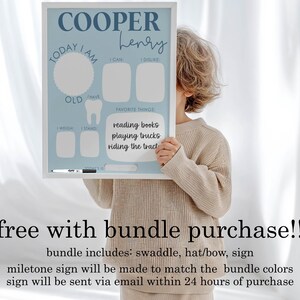 May include: A light blue milestone sign with the name "COOPER Henry" in script. The sign includes sections for "Today I am", "I can", "I dislike", "Favorite things", "Weight", and "Stand". Favorite things listed are "reading books, playing trucks, riding the tract".