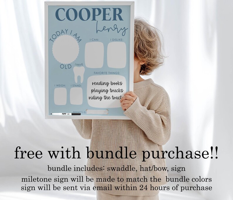 May include: A light blue milestone sign with the name "COOPER Henry" in script. The sign includes sections for "Today I am", "I can", "I dislike", "Favorite things", "Weight", and "Stand". Favorite things listed are "reading books, playing trucks, riding the tract".