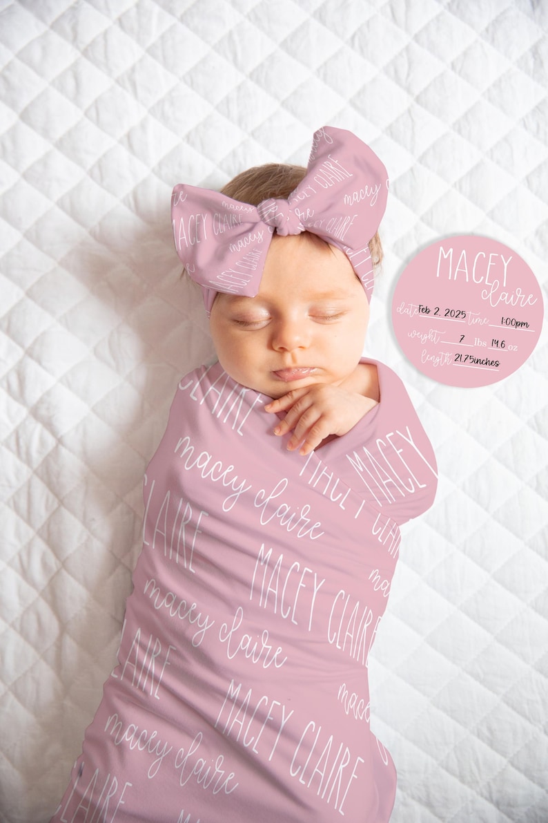 May include: A baby wrapped in a pink swaddle blanket and wearing a matching headband, both printed with the name "Macey Claire" in white script. A circular sign displays the baby's name, birth date, time, weight (7 lbs 14.6 oz), and length (21.75 inches).