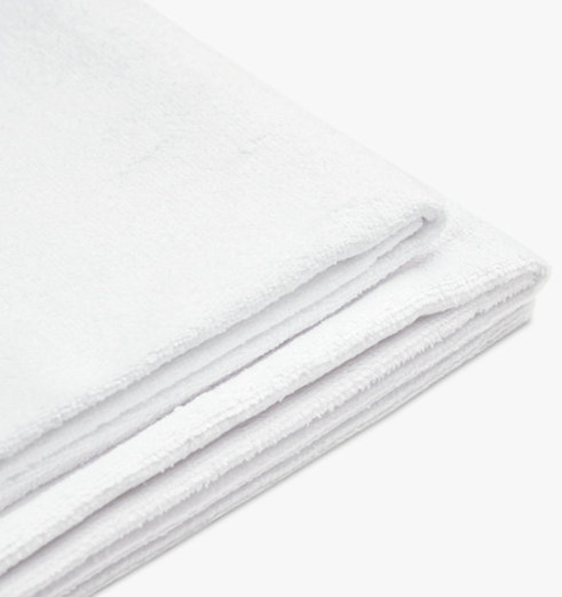 May include: A white, soft, and fluffy towel folded in thirds. The towel is made of a plush material and is perfect for drying off after a bath or shower.