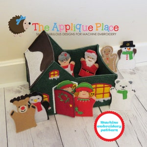 May include: A felt Christmas house puppet theater with a green exterior, brown roof, and red door. The house has windows and a chimney. There are eight felt puppets inside the house, including Santa Claus, a gingerbread man, a snowman, and two elves. There are also three felt puppets outside the house, including a reindeer, a penguin, and a polar bear. The text "The Applique Place" and "Simply Fabulous Designs for Machine Embroidery" is printed above the house. The text "Machine embroidery pattern" is printed below the house.
