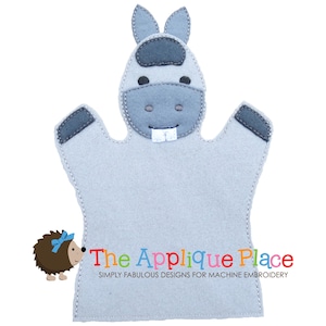May include: A light gray felt donkey hand puppet with dark gray accents on the ears, forehead, and hands. The puppet has white teeth and black eyes. The Applique Place logo is at the bottom, with the text "SIMPLY FABULOUS DESIGNS FOR MACHINE EMBROIDERY".