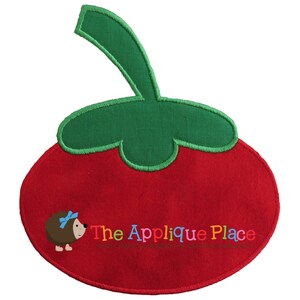 May include: A red tomato-shaped applique with a green stem and leaf. The applique features a cartoon hedgehog with a blue bow and the text "The Applique Place" in colorful letters. The design is embroidered with a stitched border.