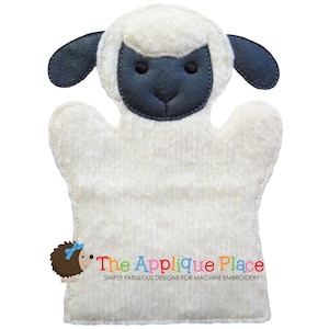 May include: A white and black sheep hand puppet made of soft fabric. The puppet has a fluffy white body, dark gray ears, and a dark gray face. The Applique Place logo is in the bottom left corner.