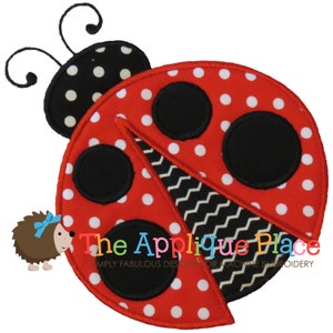 May include: A red ladybug applique with black spots and a black and white zigzag design. The ladybug has a black head with white polka dots and a small hedgehog with a blue bow. The text "The Applique Place" is visible.