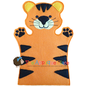 May include: Orange and black felt tiger puppet with a smiling face, whiskers, and black stripes. The puppet has a hand opening at the bottom and paw prints on the hands. The text "The Applique Place" is at the bottom.