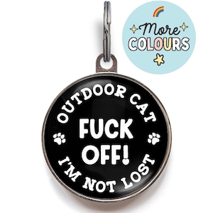 Peut inclure: Une médaille pour animal de compagnie noire et argentée avec le texte "OUTDOOR CAT FUCK OFF! I'M NOT LOST" en blanc. La médaille comporte des empreintes de pattes et une boucle métallique. Un cercle bleu clair avec le texte "+More COLOURS" et un arc-en-ciel est dans le coin supérieur droit.