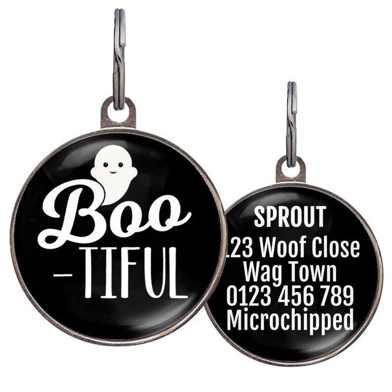 May include: Two round pet tags. One tag has a black background with the word "Boo-tiful" and a ghost graphic in white. The second tag has the pet's name, address, phone number, and "Microchipped" in white text.