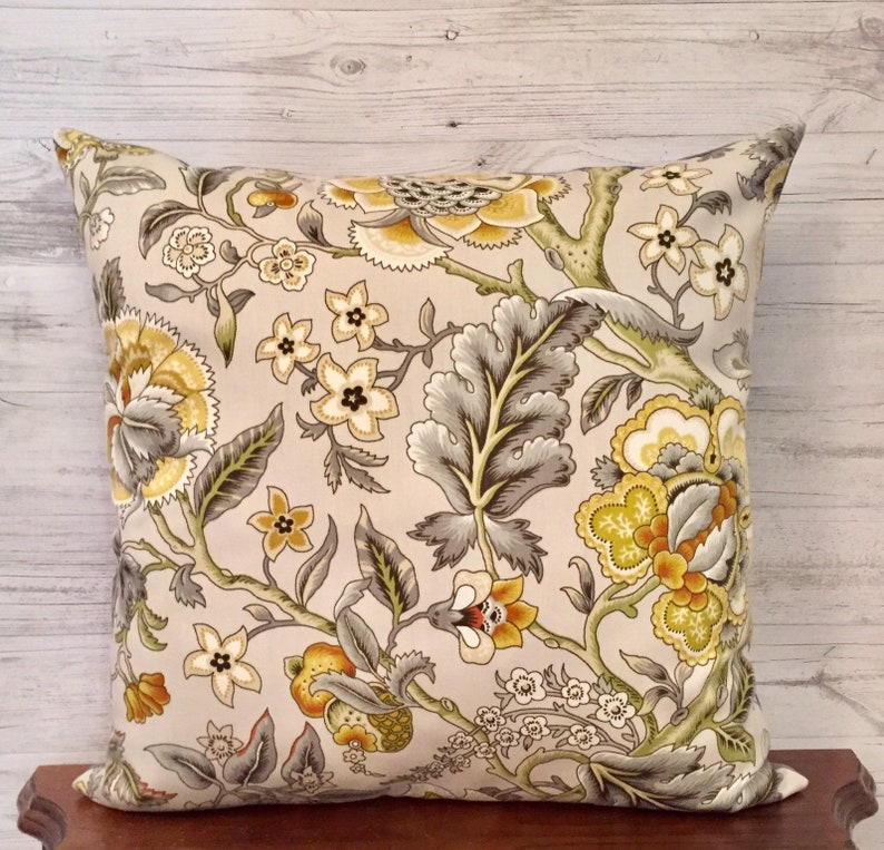 Puede incluir: Una almohada decorativa con un patr&oacute;n floral en tonos amarillos, verdes y grises. La almohada presenta un gran dise&ntilde;o floral con detalles intrincados.