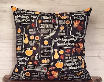 May include: Black and white throw pillow with a Thanksgiving theme. The pillow features a variety of designs including pumpkins, turkeys, sunflowers, and leaves. The text on the pillow reads "Thanks with a Grateful Heart", "Happy Thanksgiving", "Love of Family", "Love of Friends", "Thankful and Blessed", and "Give Thanks".