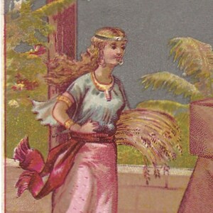 May include: A woman in a pink dress and a blue tunic holds a sheaf of wheat. She is wearing a gold crown and a red sash. The background is a pale blue sky with palm trees.