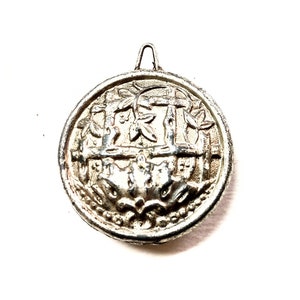 May include: Silver-toned metal button with an intricate design featuring a stylized tree and a fence. The button has a loop on the top for attaching to clothing.