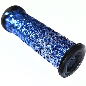 May include: A blue, cylindrical object with a textured, glittery surface. The ends are capped with black rubber. The object is set against a white background.