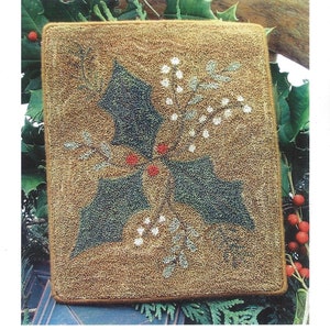 May include: A punchneedle embroidery project titled "Mistletoe and Holly." The design features green holly leaves, white berries, and red berries on a tan background. The finished piece measures 5.75 inches by 7.25 inches.