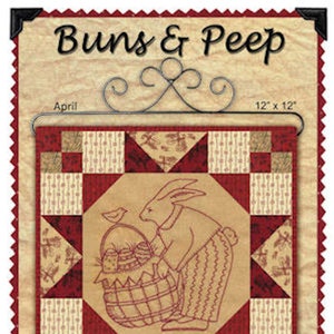 May include: A framed quilt with the text "Buns & Peep" and a drawing of a rabbit with a basket. The quilt is 12 x 12 inches and has a red and tan color scheme. The image includes the text "April" and a poem.
