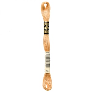 May include: A skein of DMC embroidery floss in color 437, a light beige. The floss is wound on a white card with a gold label that reads "DMC" and "25m (87 yds)".