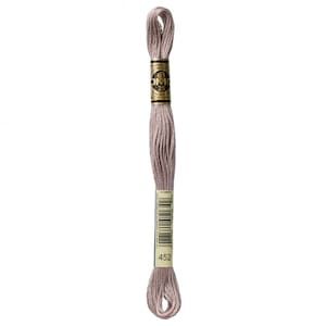 May include: A skein of DMC embroidery floss in color 452, a light beige shade. The floss is wound around a cardboard spool with a gold label that reads "DMC" and "25m (82 yds)".