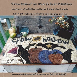 May include: A hand-hooked rug depicting a crow hollow scene with two crows, pumpkins, and a sunflower. The rug is 20 inches by 33 inches and is made with hand-dyed wool. The rug is displayed on a wooden table with a rustic finish.