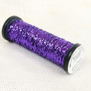 May include: A spool of purple metallic thread with a label that reads "UKRAINIKA METALLIC THREAD 012HL BALGER"