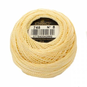 May include: A skein of DMC embroidery floss in color 745, a pale yellow. The skein is labeled with the DMC logo, the color number, and the barcode. The skein is 10 grams.