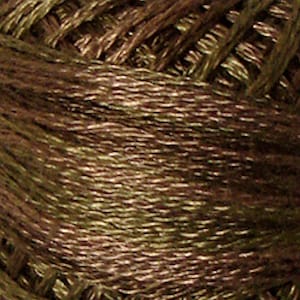 May include: Close-up of a spool of brown and gold embroidery floss.