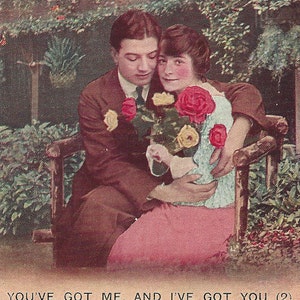 May include: A vintage Valentine's Day card featuring a couple embracing on a bench with a bouquet of red and yellow roses. The text reads "You've got me, and I've got you (2)."