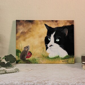 Puede incluir: Una pintura de un gato blanco y negro con ojos verdes mirando a un peque&ntilde;o rat&oacute;n marr&oacute;n que sostiene una fresa roja. El fondo es de color amarillo-marr&oacute;n con hierba verde.