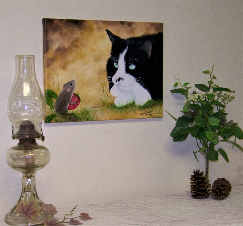 Puede incluir: Una pintura de un gato blanco y negro con ojos azules mirando a un peque&ntilde;o rat&oacute;n marr&oacute;n que sostiene una fresa roja. El fondo es de color marr&oacute;n claro con follaje verde.
