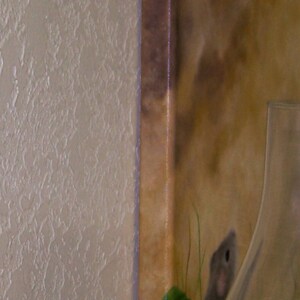 Puede incluir: Un primer plano de una pintura sobre lienzo que presenta un peque&ntilde;o rat&oacute;n marr&oacute;n con plantas verdes y un jarr&oacute;n de vidrio transparente. La pintura tiene un fondo marr&oacute;n con un borde marr&oacute;n claro.