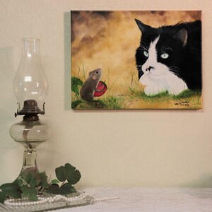 Puede incluir: Una pintura de un gato blanco y negro con ojos verdes mirando a un peque&ntilde;o rat&oacute;n marr&oacute;n que sostiene una fresa roja. El fondo es un paisaje amarillo y marr&oacute;n.
