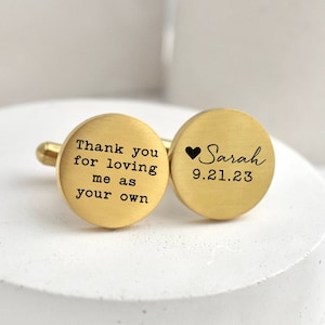 May include: Gold-colored cufflinks with engraved text. One cufflink reads "Thank you for loving me as your own." The other cufflink has a heart symbol, the name "Sarah," and the date "9.21.23."