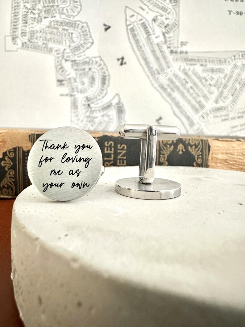 May include: Silver cufflinks with a round engraved message that reads "Thank you for loving me as your own".