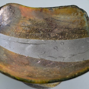 Raku fired bowl, lustre colors on grey claybody, on raised foot