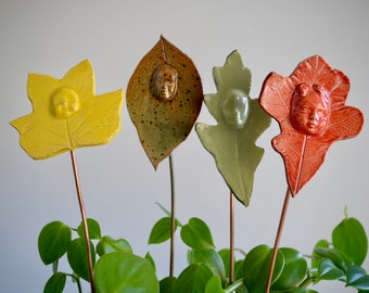 Assorted Woodsprites,  glazed ceramic leaf face on a copper stick, for potted plants or outside