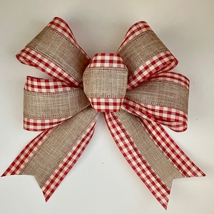 May include: A large, red and white gingham bow with a hessian centre. The bow is tied with a knot in the centre and has a rustic, farmhouse style.