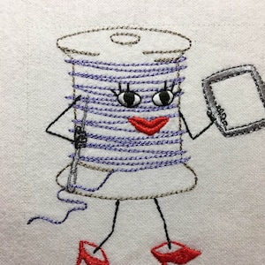 Puede incluir: Imagen bordada de una bobina de hilo con una cara, usando zapatos rojos y sosteniendo una aguja y una pequeña tableta.