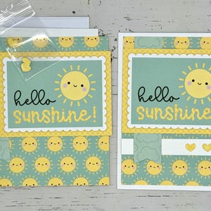 May include: Two handmade greeting cards with a yellow sun and the text "hello sunshine!" on a green background with a white border.