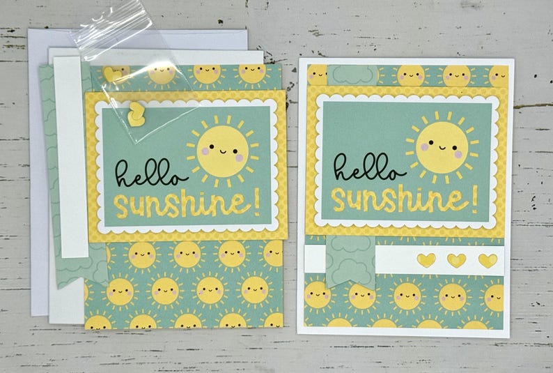 May include: Two handmade greeting cards with a yellow sun and the text "hello sunshine!" on a green background with a white border.