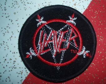 May include: Black and red embroidered Slayer band patch with a white logo and silver accents. The patch is circular and has a white border.