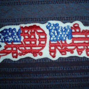 May include: A white patch with the word "RAD" embroidered in red, white, and blue, resembling the American flag.