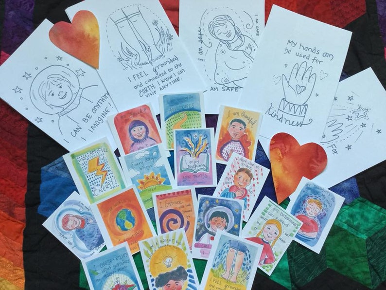 May include: A collection of colorful affirmation cards with illustrations and text. The cards feature positive messages such as "I feel grounded" and "I can be anything I imagine".