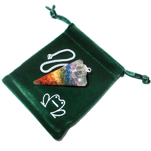May include: A seven chakra crystal pendulum with a silver chain and a green velvet pouch. The pouch has a white frog logo.
