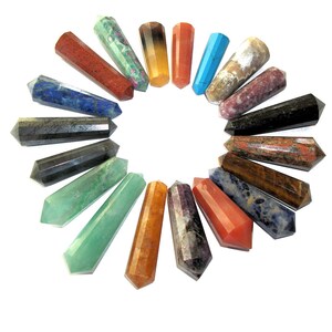 Puede incluir: Una colección de 18 puntas de cristal de colores dispuestas en círculo. Las puntas están hechas de varios tipos de piedras preciosas, incluyendo amatista, cuarzo rosa, ojo de tigre y lapislázuli.
