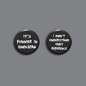 May include: Two black button badges with white text. The first badge says "It's funnier in Enochian". The second badge says "I don't understand that reference".