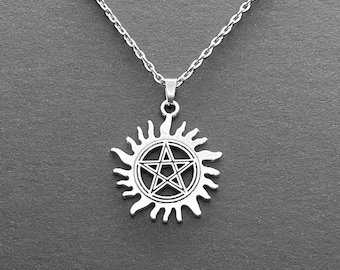 May include: A silver necklace with a pentagram inside a sunburst pendant.